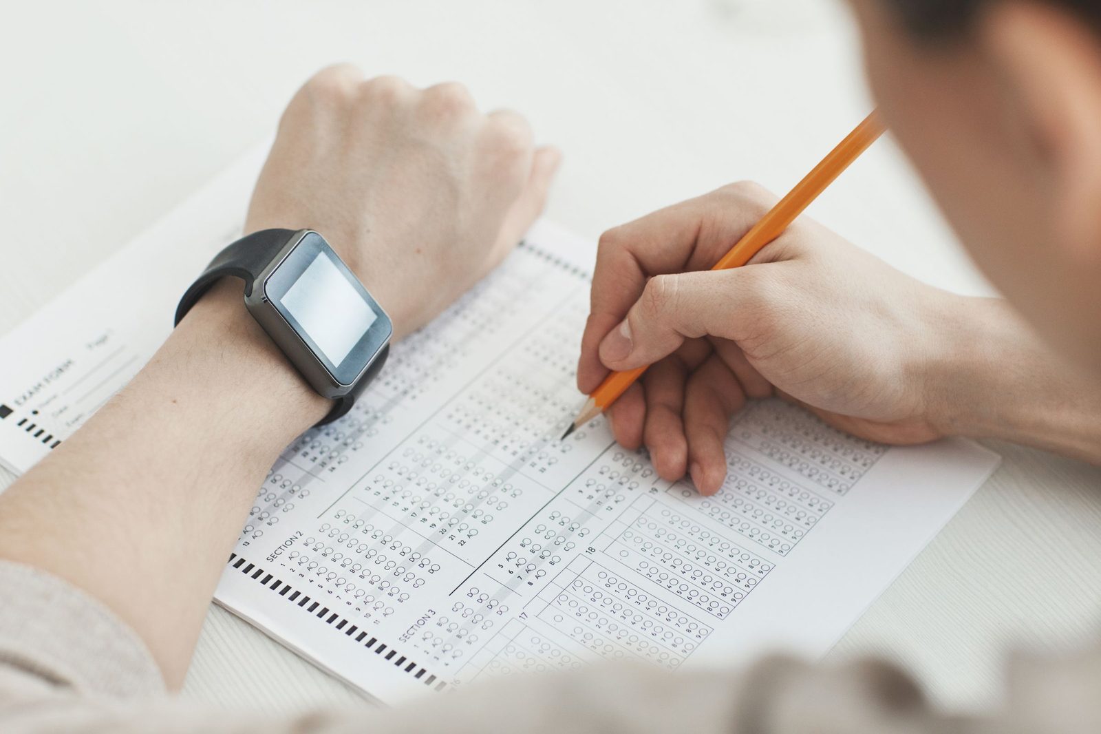 Student filling in a multiple-choice answer sheet with a pencil during ISEE and SSAT practice