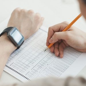 Student filling in a multiple-choice answer sheet with a pencil during ISEE and SSAT practice